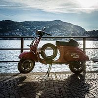 Vespa tegen een ondergaande zon aan het comomeer