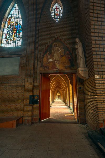 Voyage mystique : Le long passage avec les vitraux et les statues d'anges dans le monastère abandonné par Het Onbekende