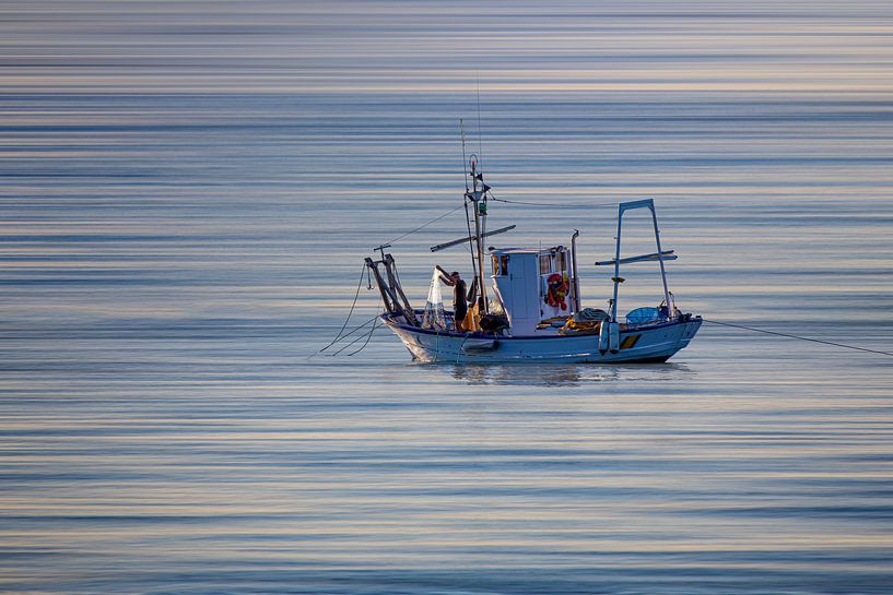 Typical fishing boat from Andalucia with a fisherman who brings in his net by Wout Kok
