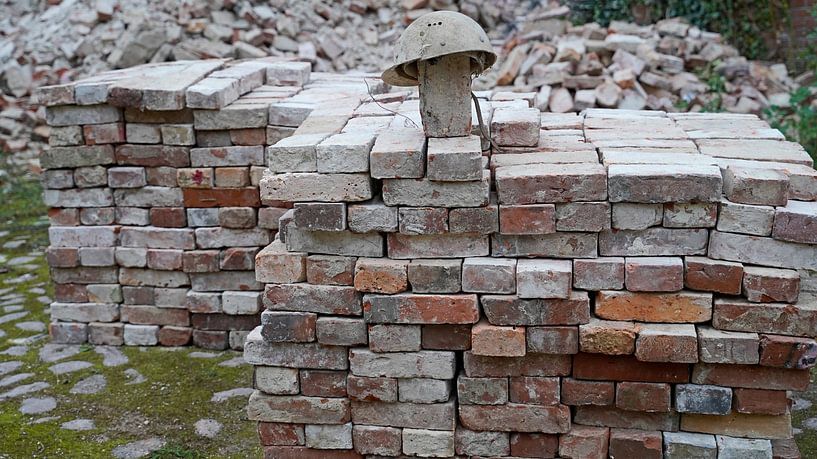 gestapelte Ziegel und alter Bauhelm auf einer Baustelle von Babetts Bildergalerie