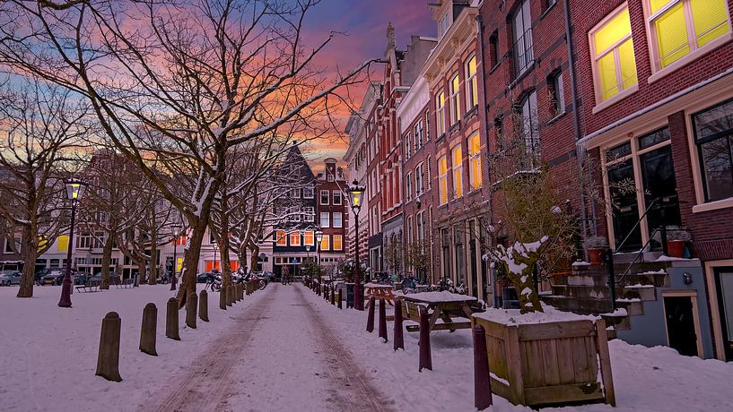 Stadtbild von Amsterdam im Schnee bei Sonnenuntergang in den Niederlanden von Eye on You