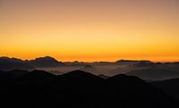 Orange sunset over foggy Alps