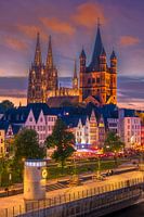 Des couleurs dorées, des rencontres animées. La vieille ville de Cologne dans sa plus belle heure du soir ! Cette photo utilise les tons chauds de l'heure dorée pour mettre en valeur l'activité sociale animée de la vieille ville sous un jour particulièrement charmant.