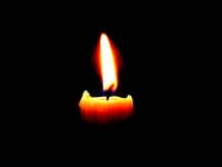 Burning candle against a black background
