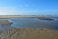 zwin in de zee met blauwe lucht water strand noordzee