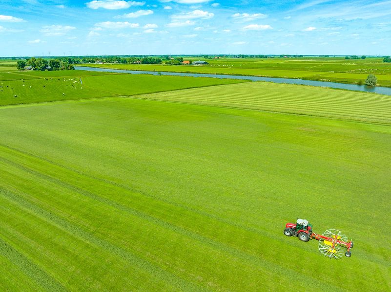 Tractor pulling a rotary rake to collect hay from a grass meadow by Sjoerd van der Wal Photography