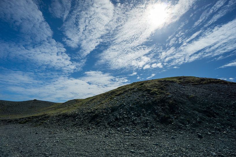 Island - Schwarze Steinhügel, bedeckt mit grünem Gras und blauem Himmel von adventure-photos