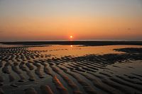 Oranger Sonnenuntergang am Strand mit Sandkämmen