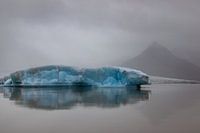 Blaue Eisscholle im nebligen Island