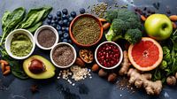 Healthy food clean eating selection: fruit, vegetable, seeds, superfood, cereals, leaf vegetable on gray  copy space