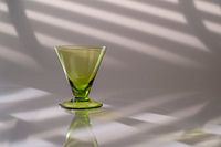 Modernes Stilleben mit grünem Glas