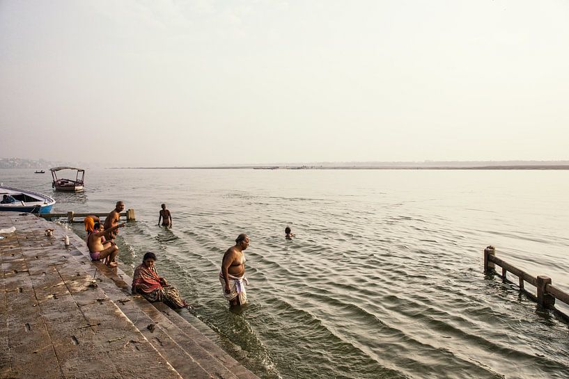 Menschen, die im Fluss Ganga in der heiligen Stadt Varanasi, Indien, rituelles Bad nehmen. von Tjeerd Kruse
