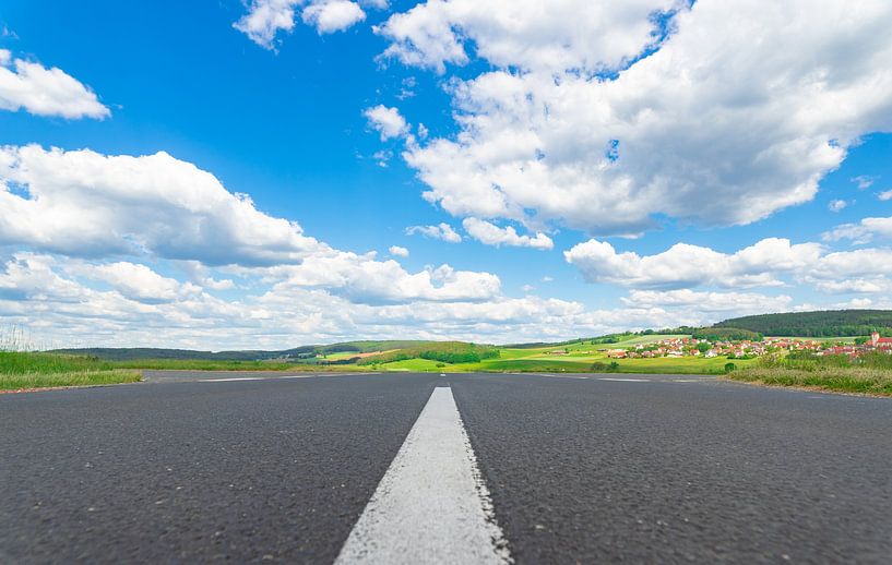 Asphaltstraße mit weißen Trennlinien, schöne Landschaft und bewölkter blauer Sonnenhimmel von Alex Winter