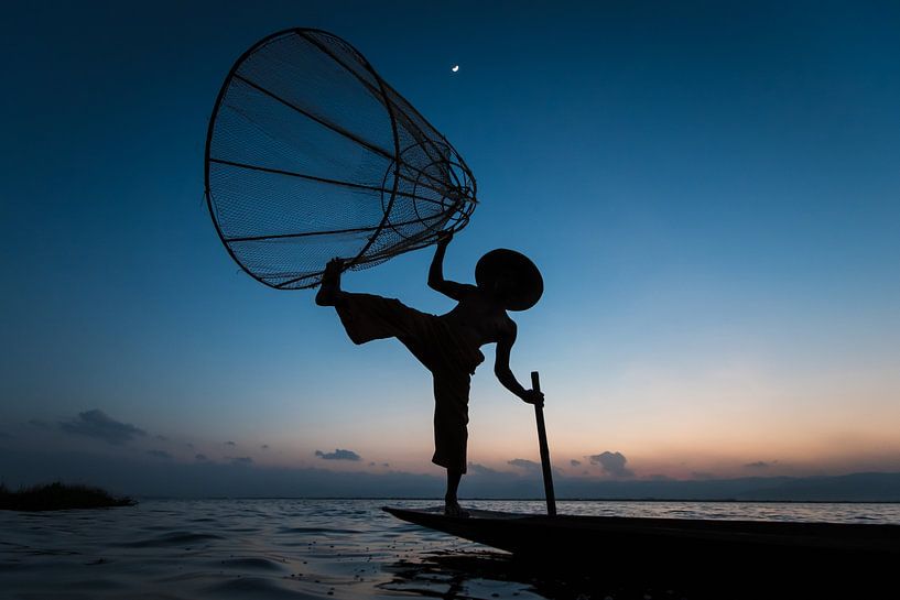 PÊCHEUR AT SUNRISE vist ON WAY TRADITIONNEL AU LAC INLE AU MYANMAR. Avec un panier du poisson est ca par Wout Kok