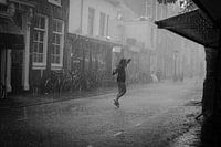 Young woman dancing in the rain in black and white