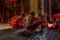 Young novice buddhists monks playing card in their Moanastery