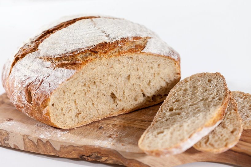 Homemade sourdough bread on a wooden board by Ans van Heck