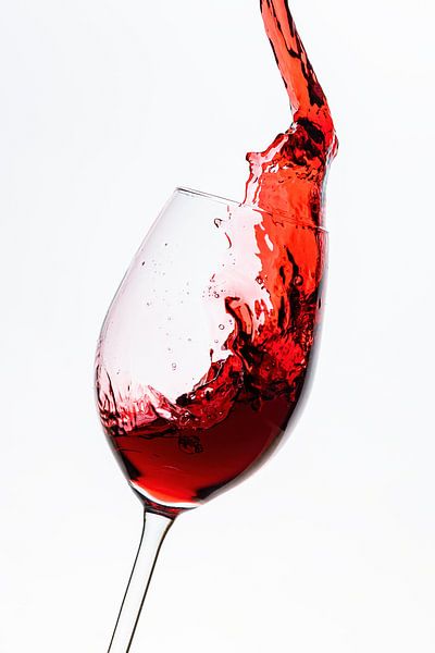 Red wine flows into the wine glass by Roland Brack
