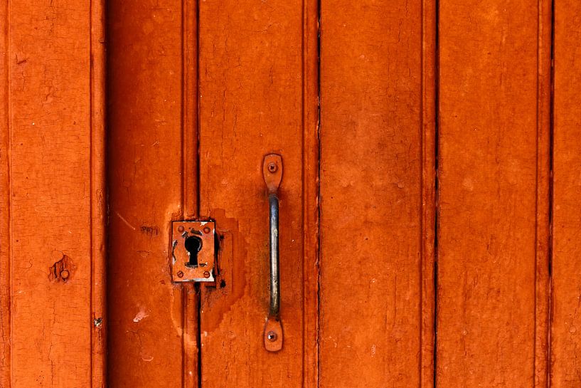 Schlüsselloch in einer rot-orangefarbenen Tür in dem Dorf Buis de Baronie in Frankreich von Cindy Mulder