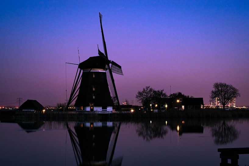 Niederländische Windmühle in der Nähe eines Flusses während der blauen Stunde von Menno van der Haven