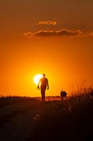 Mann mit Hund im Sonnenuntergang