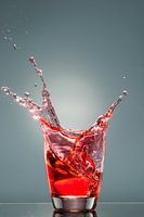 Splashes from a glass of red liquid
