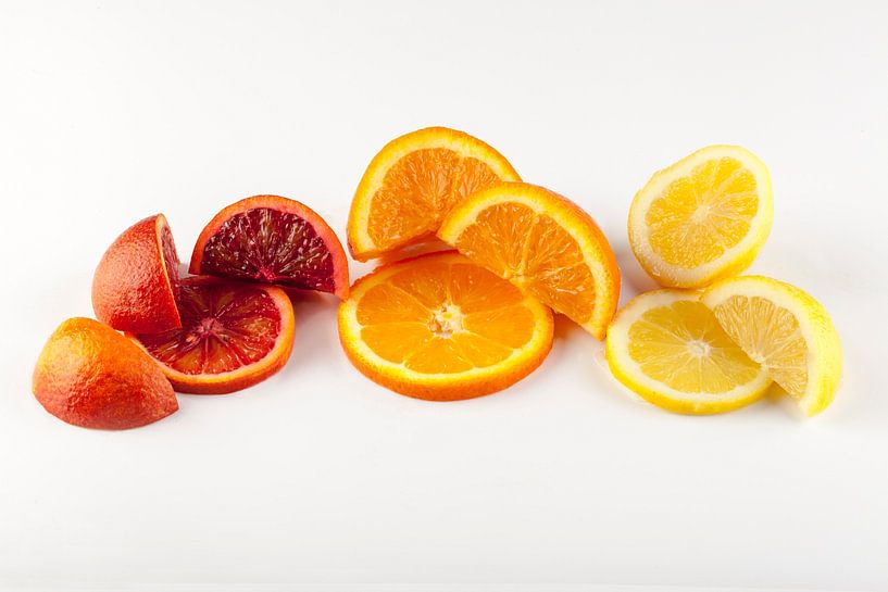 Slices and segments of citrus fruit against a light background. by Ans van Heck