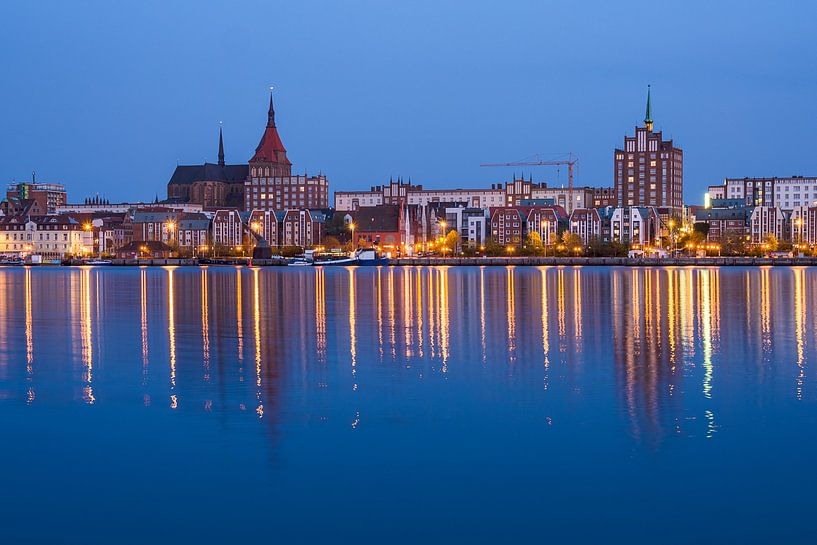 Blick über die Warnow auf die Stadt Rostock am Abend van Rico Ködder