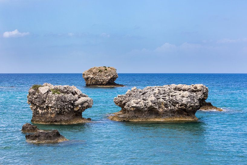Three separate rocks offshore in sea by Ben Schonewille