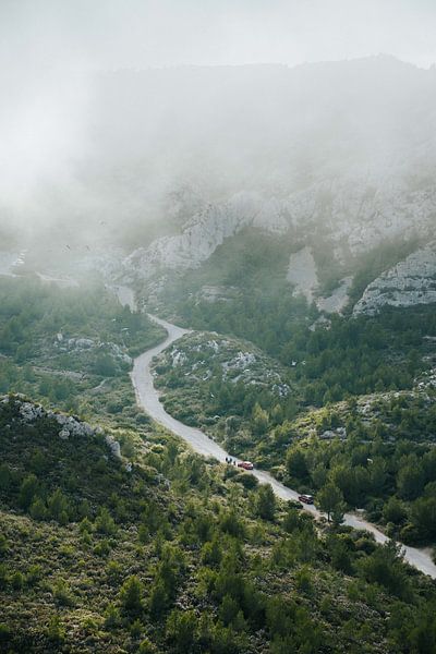 Curvy road with foggy mountain pass by Joep van de Zandt