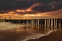 Holländische Wolken und typische Wellenbrecher von Holzpfählen entlang der Küste von Zeeland