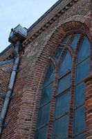 church window with next to it a rain pipe made of lead