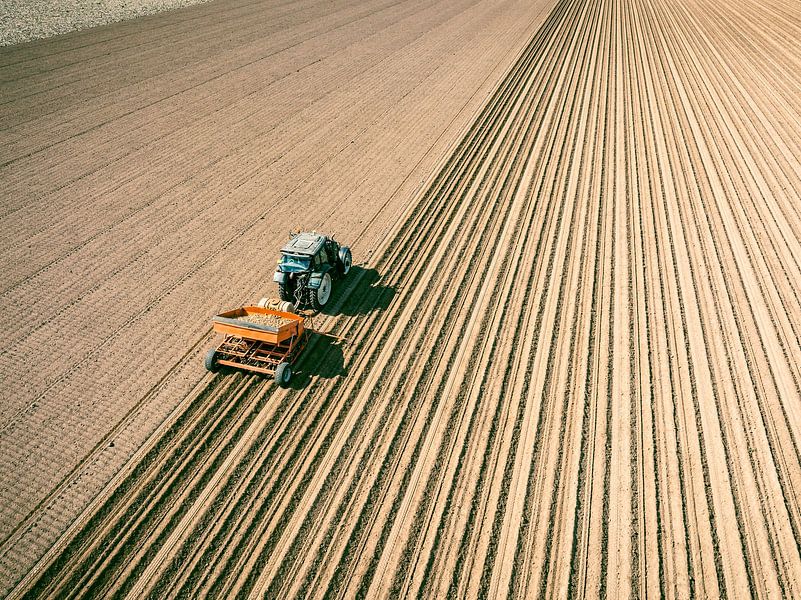 Tractor planting seed potatoes in a field during springtime by Sjoerd van der Wal Photography