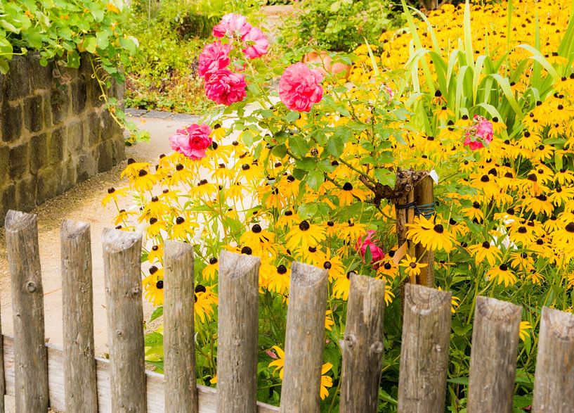 Flower garden behind a wooden fence von ManfredFotos