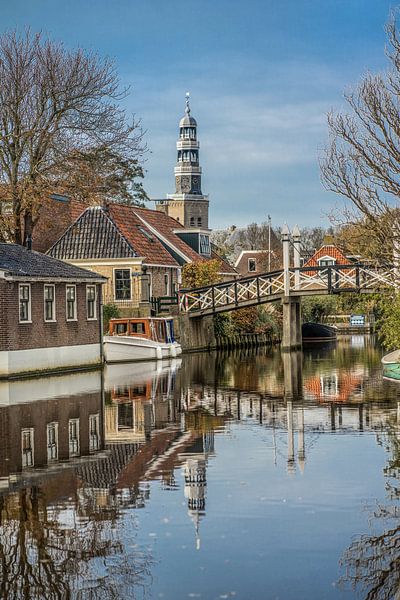 The dominant church tower of Hindeloopen with a classic bridge in the foreground by Harrie Muis