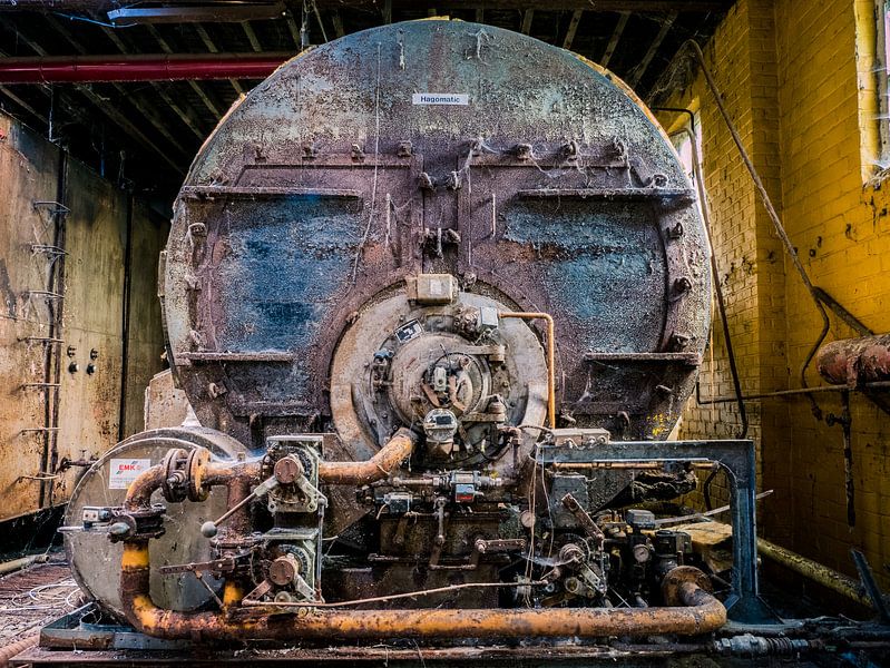 Machine (Minion) in verlaten Fabriekshal, België van Art By Dominic