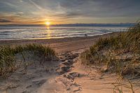 Ein Weg durch die Dünen führt zum Strand, wo Sie die untergehende Sonne genießen können.