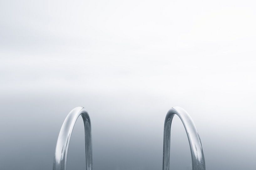 Abstraktes Schwarz-Weiß-Foto einer Metalltreppe in der Nähe eines Sees im Nebel von Bas Meelker