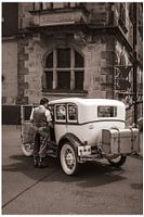 A journey through time - gentleman in a historical outfit on a vintage car