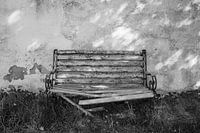 Verwitterte Gartenbank vor alter Hausmauer