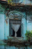 Een prachtig raam van een vervallen kolonistisch gebouw in Myanmar