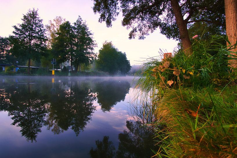 A sunrise at dawn, with mist on the river and a warm light atmosphere by Martin Köbsch