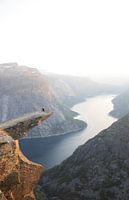 One person sits on the Trolltunga in Norway at sunset