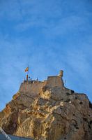 Das Castillo de Santa Bárbara in Alicante auf einem felsigen Berg unter einem klaren blauen Himmel.