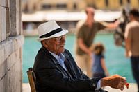 Locale, markante man op zijn stoel in de schaduw