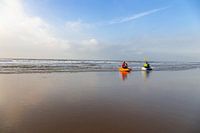 watersporters met kano langs de vloedlijn