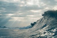 Overturning wave with Jacob's ladder in the background near the North Sea beach at Terschelling