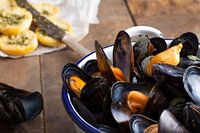 Une photo atmosphérique de palourdes avec du pain grillé et pesto