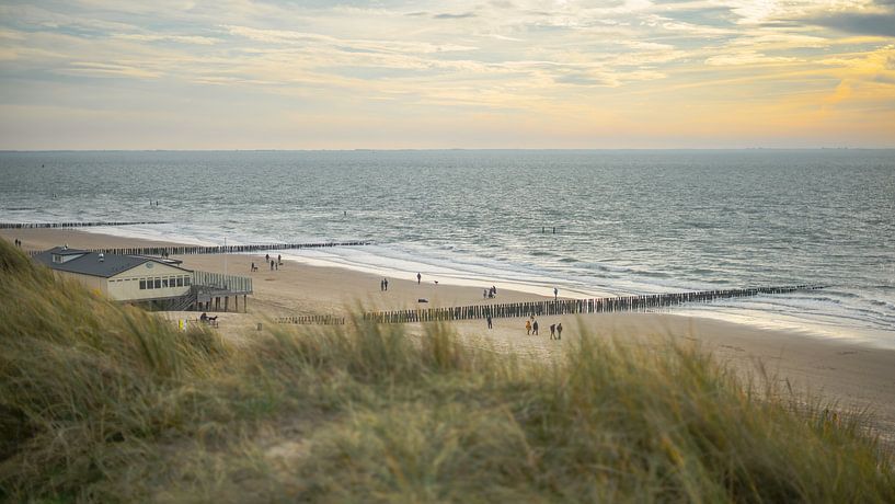 People walking past the beach house in the winter by Martijn de Bruin
