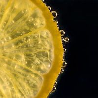Slice of lemon in water with bubbles